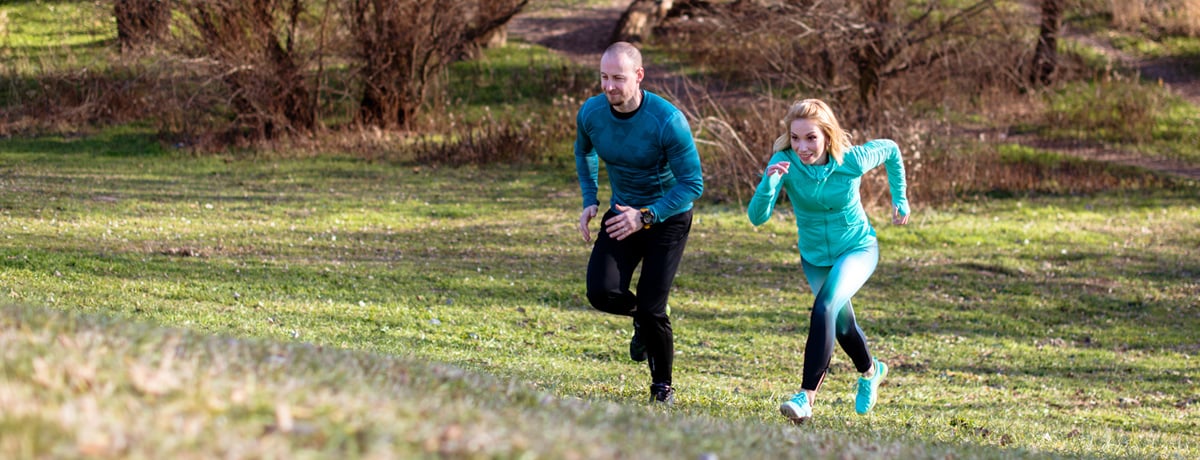 Middle-aged couple running in nature